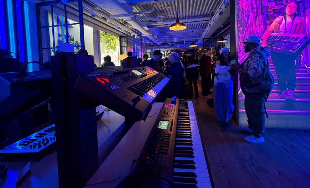 Roland synthesizers and guests under purple and blue lights at the New York flagship opening