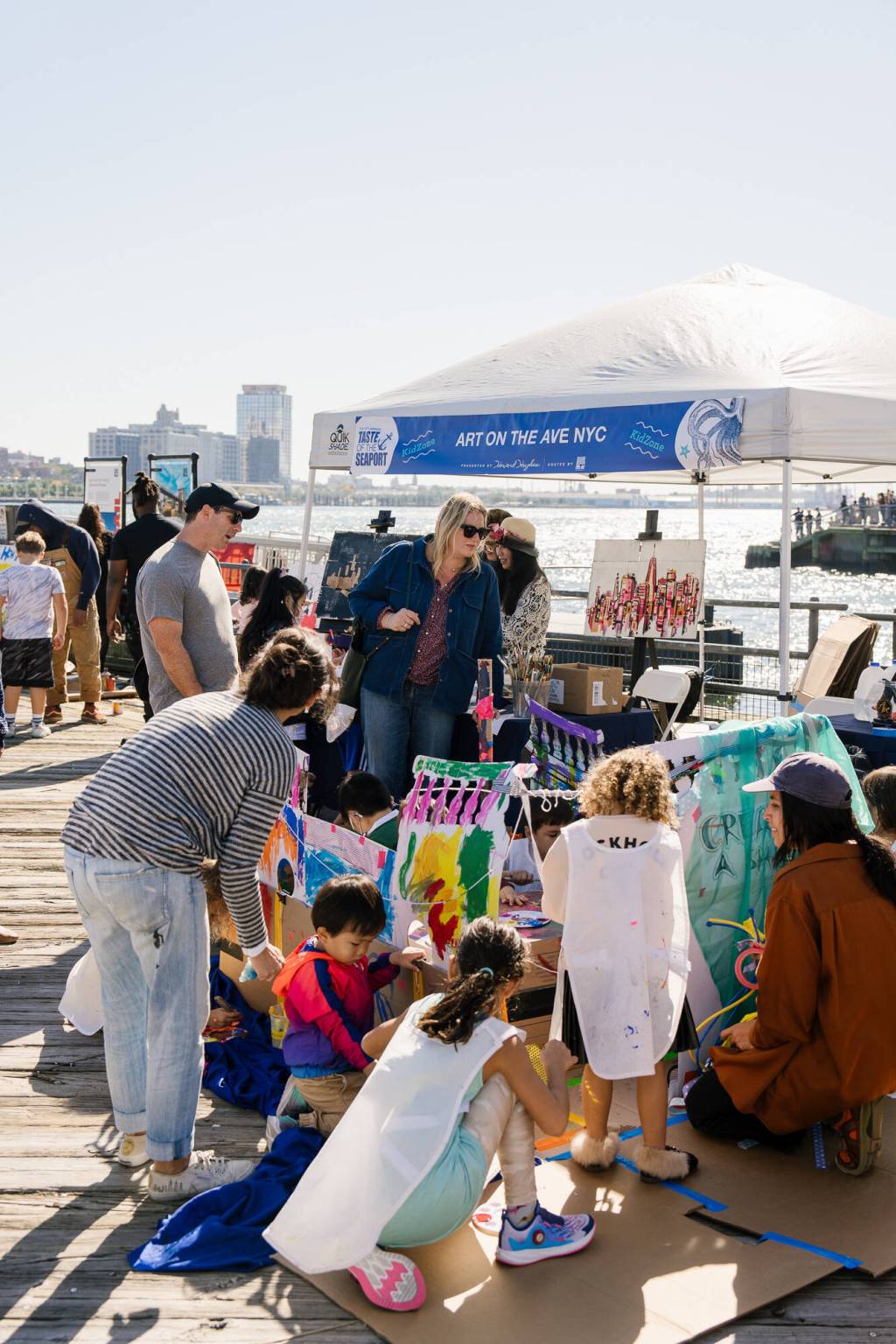 Children and families at a waterfront art activity during Taste of the Seaport