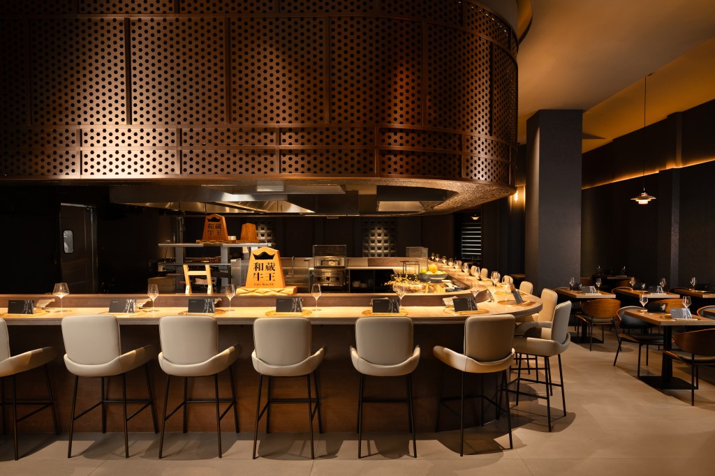 Interior of Togyushi in New York, with cream stools around an open kitchen